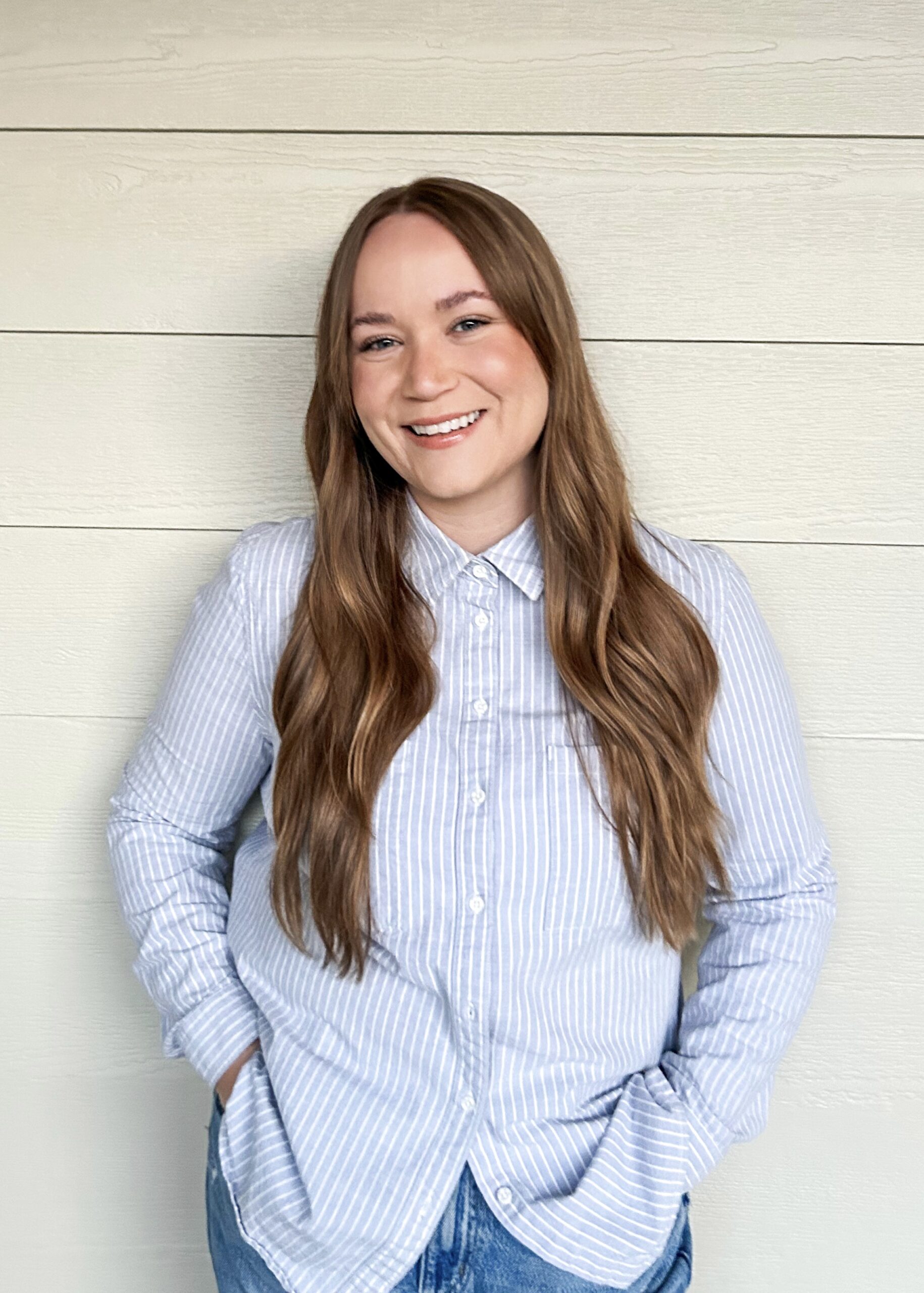 Bobbi standing in front of a wood planked wall. Conscientia Counselling